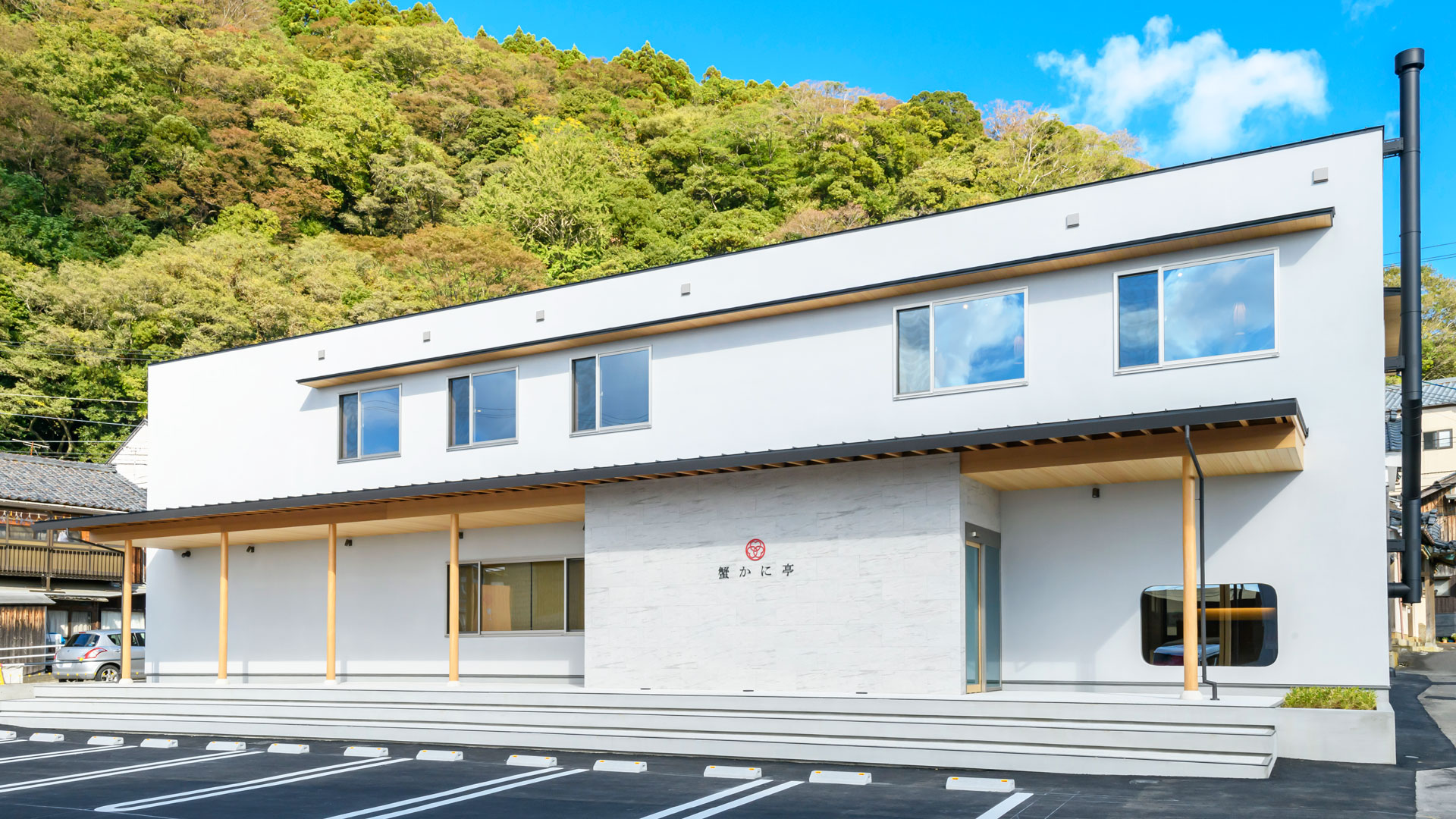 緑の山を背に建つ蟹かに亭本店